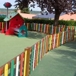 Clôture en bois coloré autour d'une aire de jeux
