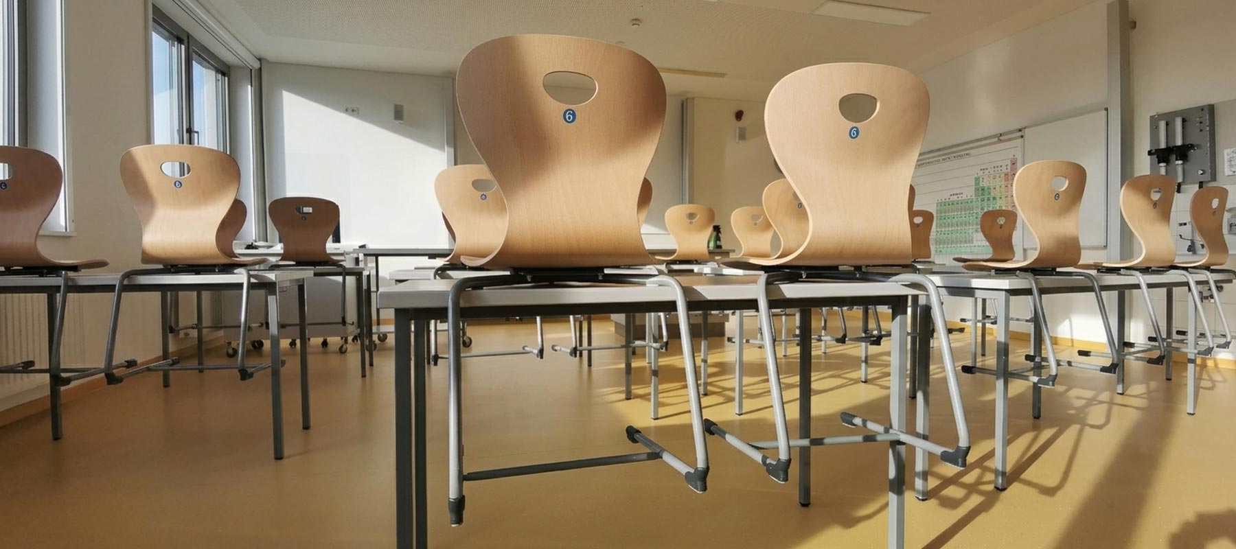 chaises scolaires appui sur tables sur des bureaux dans une salle de classe